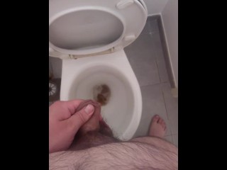 Jeune mec poilu pisse aux toilettes